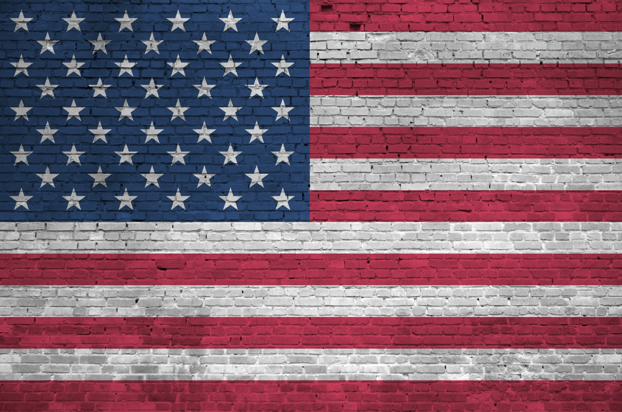 United States of America flag depicted in paint colors on old brick wall close up